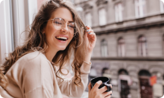 close-up-portrait-laughing-brunette-girl-beige-sweater-drinking-coffee-city-background