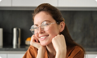 portrait-lovely-happy-young-woman-wearing-glasses-sitting-kitchen-with-dreamy-thoughtful-face